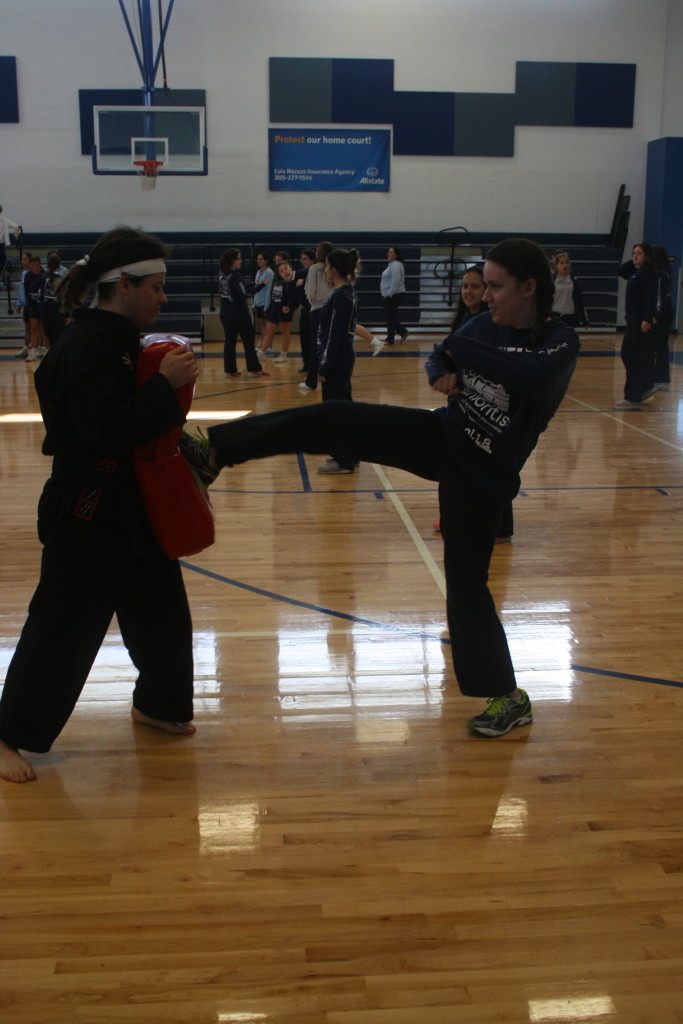 Sensei Xavier helps a student with her front kick